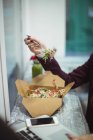 Mittelteil der Frau mit Laptop beim Salatessen — Stockfoto