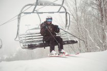 Чоловік піднімається на лижний підйомник на гірськолижному курорті — стокове фото