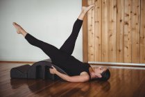 Mujer haciendo ejercicio con arco de yoga en el gimnasio - foto de stock