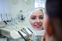 Paciente olhando para o rosto no espelho na clínica da pele — Fotografia de Stock