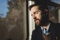 Uomo d'affari che dorme mentre viaggia in treno — Foto stock