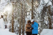 Skier couple checking the address card together on snowy mountain — Stock Photo