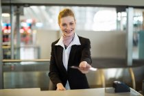 Airline check-in attendant giving passport at counter in airport terminal — Stock Photo