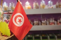 Крупный план турецкого флага и банки сладостей у прилавка в магазине — стоковое фото