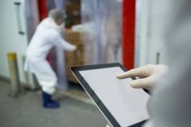 Technicien utilisant tablette numérique à l'usine de viande — Photo de stock
