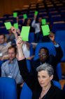 Führungskräfte der Wirtschaft zeigen ihre Zustimmung, indem sie im Konferenzzentrum die Hände heben — Stockfoto