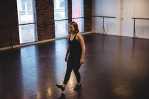 Женщина, практикующая современный танец в танцевальной студии — стоковое фото