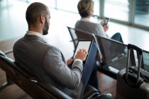 Бізнесмен використовує цифровий планшет у зоні очікування в терміналі аеропорту — стокове фото
