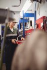 Meccanico femminile che organizza gli strumenti in toolkit al garage di riparazione — Foto stock