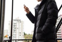 Mann benutzt Handy auf Balkon — Stockfoto