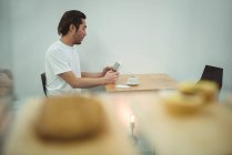 Homme utilisant tablette numérique dans un café avec une tasse de café sur la table — Photo de stock