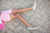 Крупним планом несвідома дівчина впала на землю після нещасного випадку — стокове фото