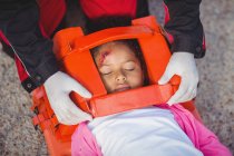 Раненая девушка, которую лечил парамедик в месте аварии — стоковое фото