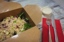 Close-up de salada de quinoa fresca em mesa de madeira com garfo e faca — Fotografia de Stock