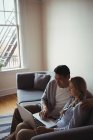 Пара використовує ноутбук у вітальні вдома — стокове фото
