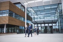 Group of business people walking outside the entrance of an office building — Stock Photo