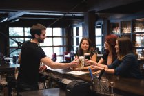 Bartender servindo cerveja para os clientes no balcão do bar — Fotografia de Stock