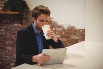 Бізнесмен використовує цифровий планшет, маючи каву в кафе — стокове фото