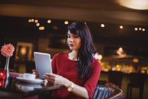Mujer usando tableta digital en restaurante - foto de stock