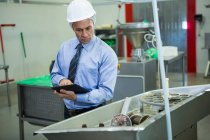 Technician inspecting while using digital tablet at meat factory — Stock Photo