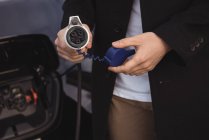 Media sezione di uomo in possesso di caricabatterie per auto — Foto stock