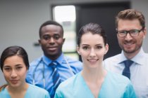 Portrait of smiling medical team standing together in hospital corridor — Stock Photo