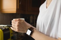 Frau mit Kaffeetasse in der Küche zu Hause — Stockfoto