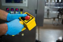 Abgeschnittene Hand eines Arbeiters mit gelben Maschinen in Fabrik — Stockfoto