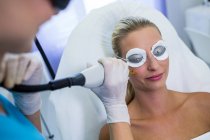 Female patient receiving laser epilation treatment on face at beauty salon — Stock Photo