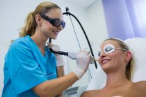 Female patient receiving laser epilation treatment on face at beauty salon — Stock Photo