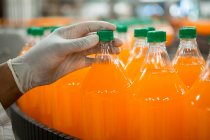 Arbeiter untersucht Flaschen in Saftfabrik — Stockfoto