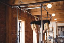 Подтянутая женщина практикует пилатес на тренажерах в фитнес-студии — стоковое фото