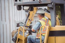 Чоловік працює бульдозером на будівельному майданчику — стокове фото