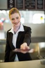 Flugbegleiterin gibt Pass am Schalter im Flughafenterminal ab — Stockfoto