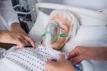 Medici che esaminano pazienti anziani con stetoscopio in letto d'ospedale — Foto stock