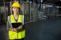 Portrait of beautiful young woman holding digital tablet in warehouse — Stock Photo