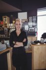 Портрет офіціантка, стоячи з руки пересічена в кафе — стокове фото