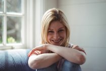 Porträt einer glücklichen Frau auf Sofa im Wohnzimmer — Stockfoto