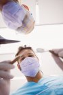Низкий угол обзора стоматологов, держащих инструменты в стоматологической клинике — стоковое фото
