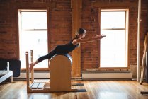 Вид сбоку женщины, практикующей пилатес в фитнес-студии — стоковое фото