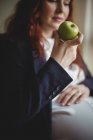 Вагітна бізнес-леді тримає яблуко в офісі — стокове фото