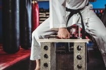 Karate-Spieler bricht Holzplanke im Fitnessstudio — Stockfoto