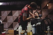 Reflexão do homem recebendo barba aparada com tesoura na barbearia — Fotografia de Stock