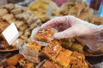 Primer plano de la vendedora organizando dulces turcos en el mostrador de la tienda - foto de stock