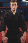 Giovane giocatore di karate adulto che esegue una posizione di karate in palestra — Foto stock