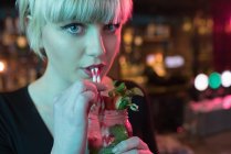 Ritratto di bella donna che prende un cocktail al bar — Foto stock
