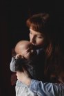 Mãe afetuosa consolando bebê chorando em casa — Fotografia de Stock