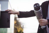 Mani dell'uomo che tiene caricabatterie per auto presso la stazione di ricarica del veicolo elettrico — Foto stock