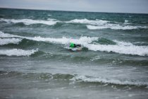 Спортсмен в мокрых костюмах плавает в море — стоковое фото