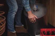 Hombre levantando mosto para hacer cerveza en casa cervecería - foto de stock